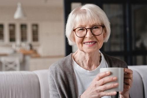 older woman with coffee after a good night's sleep