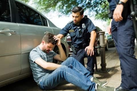 police officer helping a man who has recently been in an accident